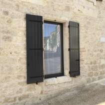 Volet battant ALU 27mm lames verticales 1 à 4 vantaux gris sur mur en pierre