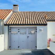 Porte de garage battante ALU à la française 2 vantaux vue extérieure hublots panneaux