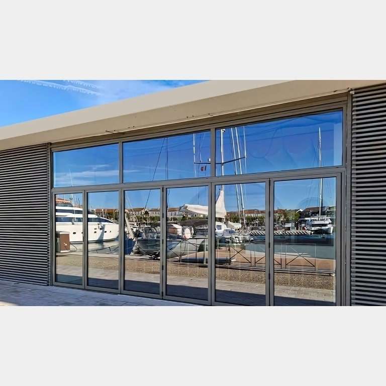 Porte pliante ALU 6 vantaux fermée dans un commerce au sein d'un port