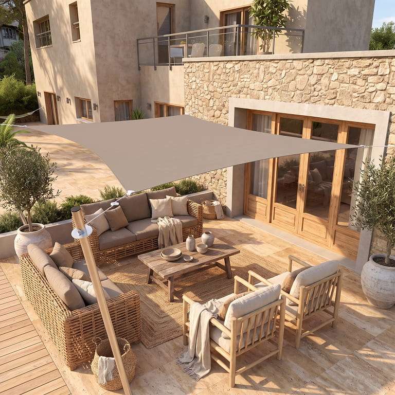 Voile d'ombrage rectangulaire sable abritant un salon de jardin sur une terrasse