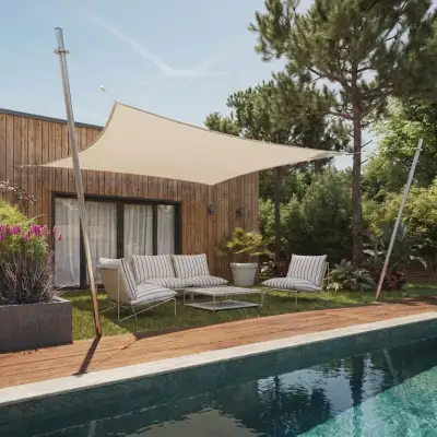 Voile d'ombrage carrée sable abritant un salon devant une piscine