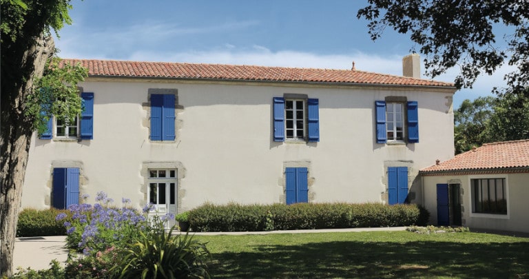 Maison de campagne avec fenêtres et volets battants en bois