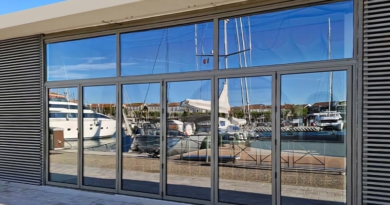 Remplacement de menuiseries - Châssis fixes en imposte au dessus de portes pliantes sur un bâtiment rénové