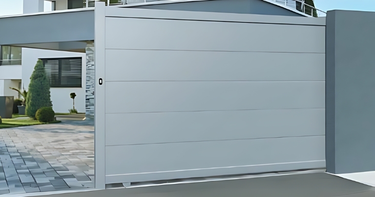 Portail ALU coulissant blanc entrouvert donnant sur une maison