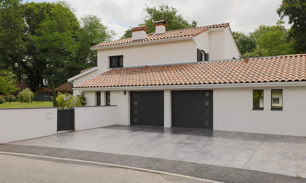 Photo d'une maison équipée d'une porte de garage sectionnelle noire