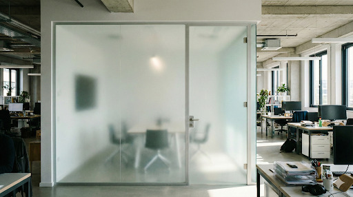 Cloison vitrée opaque séparant une salle de réunion dans un bureau open space